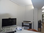 Cortina de lamas verticales con ventanas curvas en oficina